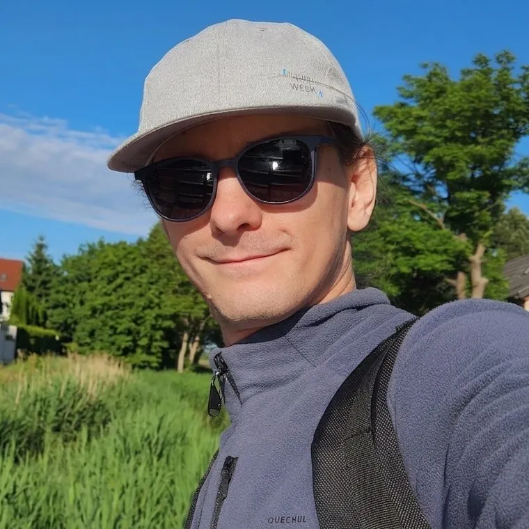 Rafał Stolarek outdoors in a cap and sunglasses